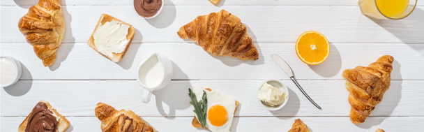 panoráma lövés édes croissant közelében ízletes pirítós és italok fehér  - Fotó, kép
