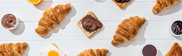 panoramatický záběr sladkých croissantů a chutného toast na bílém  - Fotografie, Obrázek