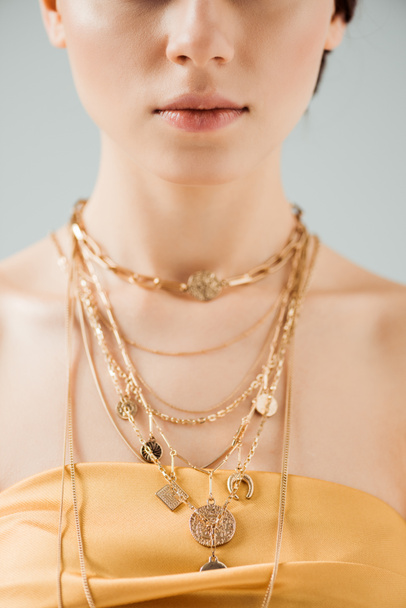 részleges kilátás a fiatal nő fényes ajkak Arany nyakláncok izolált szürke - Fotó, kép