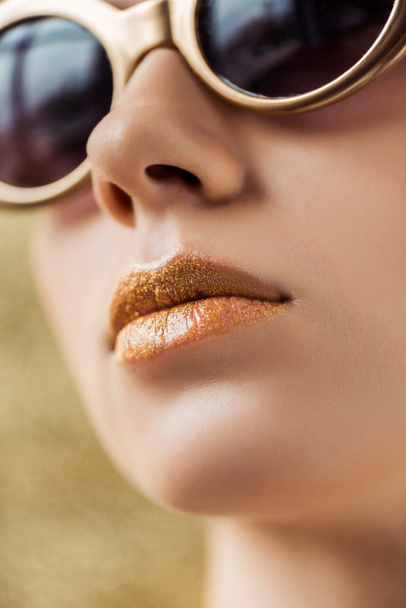 jeune belle femme en lunettes de soleil avec des lèvres dorées brillantes
  - Photo, image