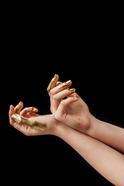 partial view of female hands painted in golden isolated on black - Photo, Image