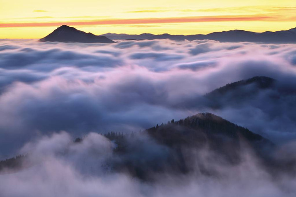 luonnonkaunis näkymä vuorille pilvissä auringonlaskun aikaan
  - Valokuva, kuva