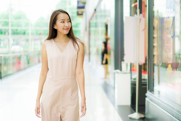 Hermosa mujer asiática sonrisa y feliz en el centro comercial de los grandes almacenes interiores
 - Foto, imagen