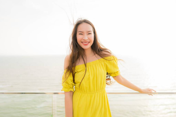 Portrait beautiful young asian woman smile happy and relax at outdoor balcony with sea beach and ocean view for leisure travel and vacation - Φωτογραφία, εικόνα