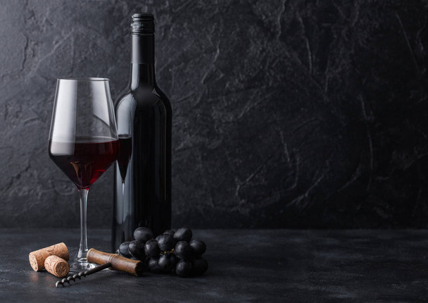 Elegant glass and bottle of red wine with corks and corkscrew on - Fotó, kép