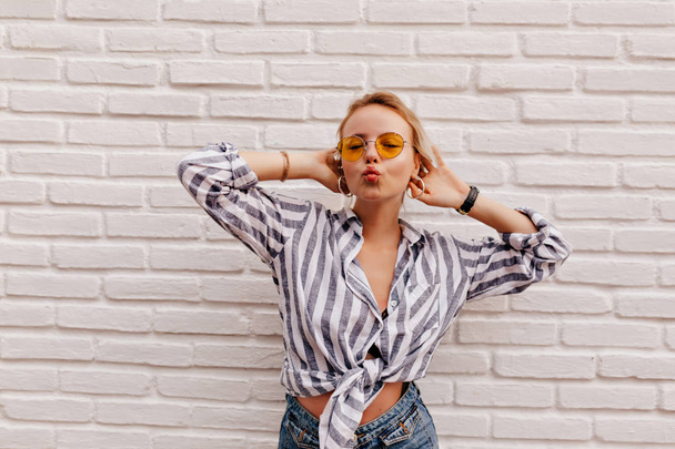 Attractive stylish caucasian woman with blond hair wearing stripped shirt sending a kiss  over isolated background  - Valokuva, kuva