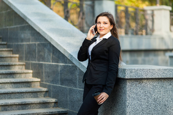 Businesswoman talking on phone while walking outdoor - Photo, Image