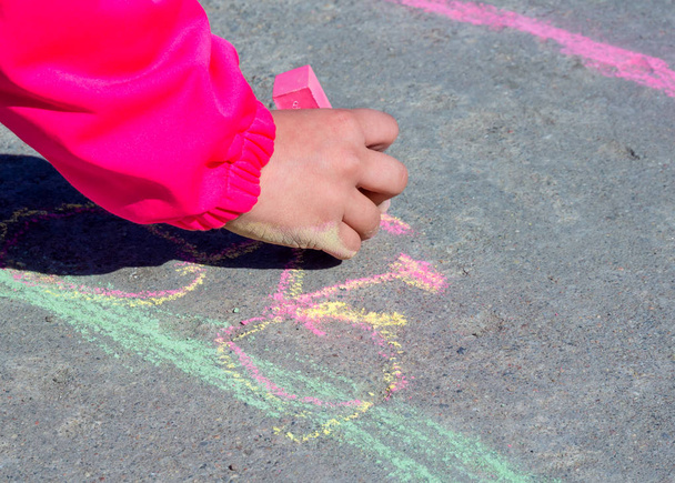 Το χέρι των παιδιών ζωγραφίζει με κιμωλία στην άσφαλτο - Φωτογραφία, εικόνα