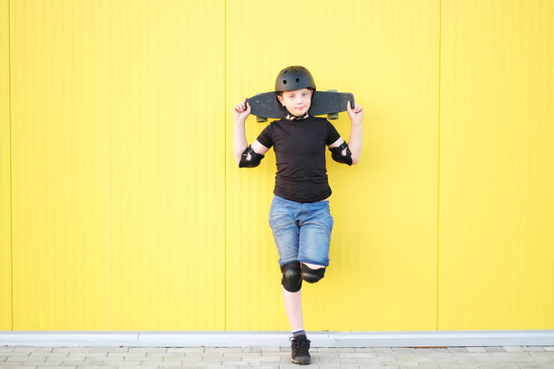 Young boy holding a skateboard on arms. - Photo, Image