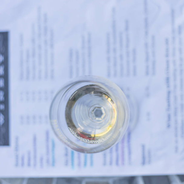 Pojem degustace vína se sklenkou suchého bílého vína a degustační menu - Fotografie, Obrázek