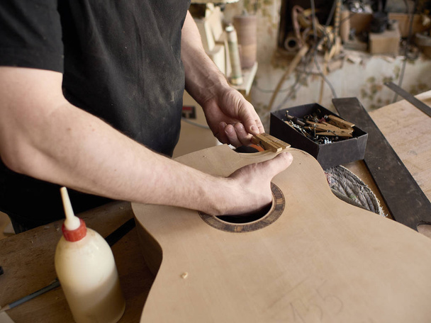 The process of making a cutaway on classical guitar. - Fotó, kép