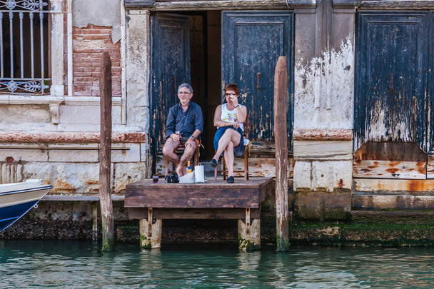 Tourists sitting on a home mooring in Venice - Zdjęcie, obraz
