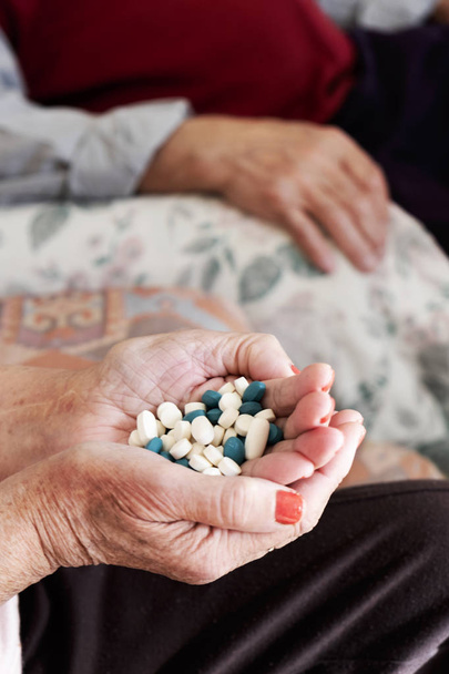 ηλικιωμένη γυναίκα με ένα σωρό από χάπια στο χέρι του - Φωτογραφία, εικόνα