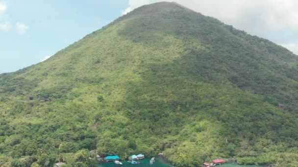 航空写真:バンダ諸島活火山グヌンアピ観光リゾートマルクインドネシア緑豊かな緑の森ターコイズウォーターサンゴ礁の旅行先の上を飛ぶ。ネイティブシネのようなD-logカラープロファイル - 映像、動画