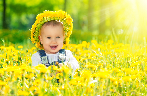 niña feliz en una corona en el prado con flores amarillas en t
 - Foto, imagen