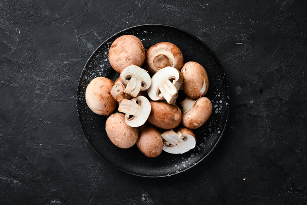 Mushrooms in a plate. Champignons on the old background. Top view. Free copy space. - Foto, immagini