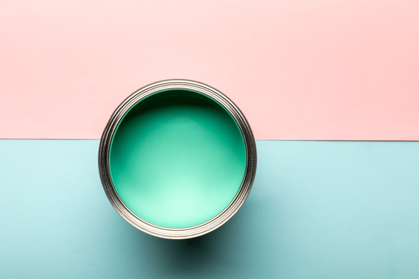 top view of tin with green paint on pink and blue surface - Fotoğraf, Görsel