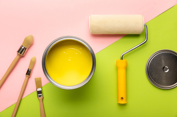 pembe ve yeşil yüzeyüzerinde sarı boya, fırçalar ve boya rulo ile kinem üst görünümü - Fotoğraf, Görsel