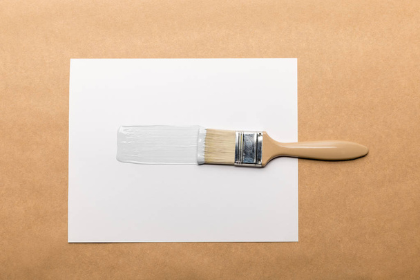 kahverengi üzerine izole edilmiş fırça ve kağıdın üst görünümü - Fotoğraf, Görsel