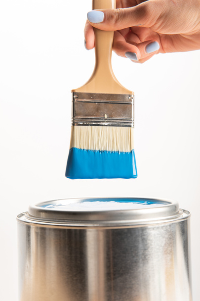 partial view of woman holding brush with blue paint isolated on white - Fotó, kép