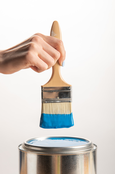 partial view of woman holding brush with blue paint isolated on white - Photo, Image