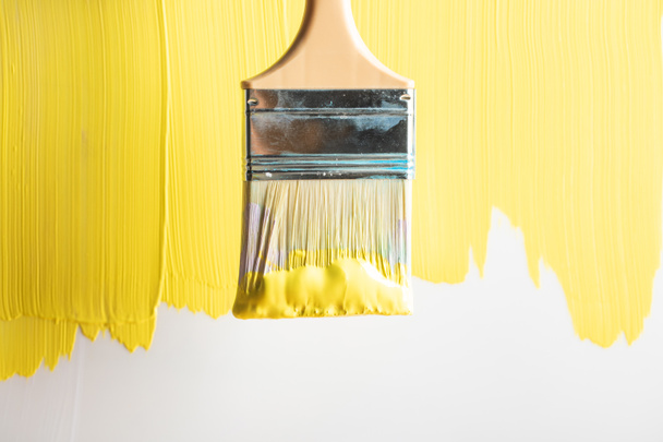 top view of brush on painted yellow surface - Photo, Image