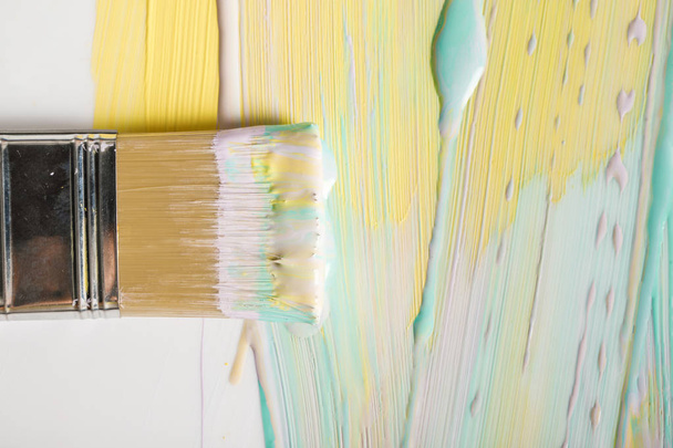 top view of brush and colorful brushstrokes on white surface - Fotografie, Obrázek