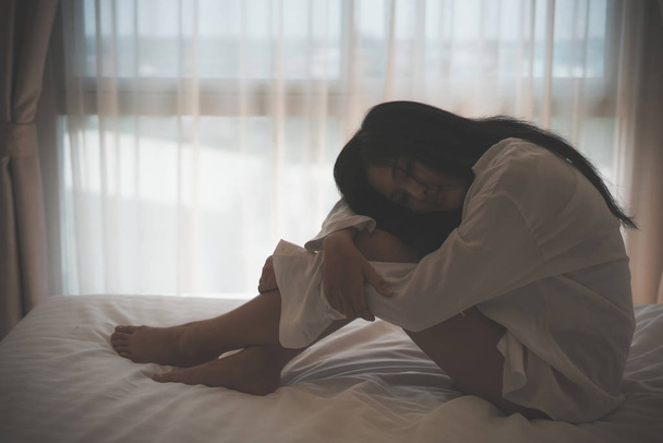 mujer se siente triste presionada y sentada en su cama
 - Foto, Imagen