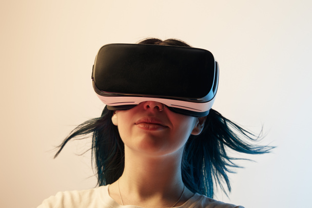 Brünettes Mädchen trägt Virtual-Reality-Headset auf beige  - Foto, Bild
