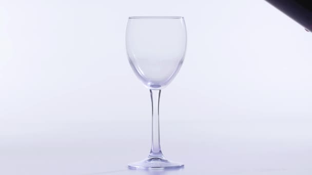 Concetto di cibo e bevande. Vino rosso o rosa versato in un bicchiere su fondo bianco
. - Filmati, video