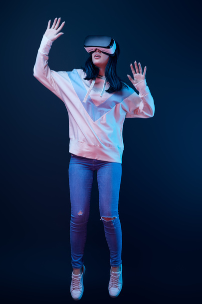 Brunette fiatal nő golgozva viselése közben virtuális valóság headset kék  - Fotó, kép