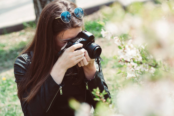 beautiful young woman taking pictures of flowering trees - Photo, image
