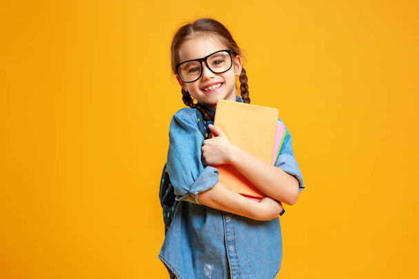 αστείο παιδί σχολείο κορίτσι στο κίτρινο φόντο    - Φωτογραφία, εικόνα