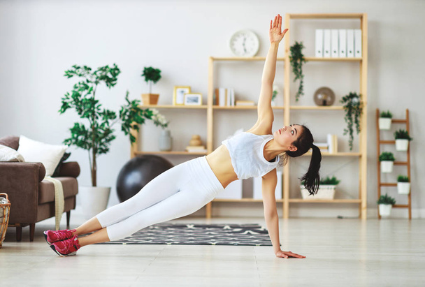 jonge vrouw bezig met fitness en sport thuis    - Foto, afbeelding