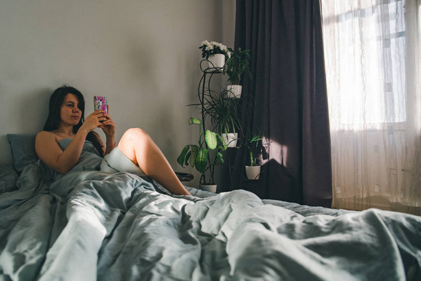 woman morning. in bed with phone. - Foto, Imagen