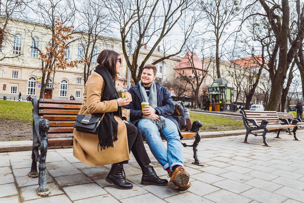 jeune couple adulte manger fast food sur le banc du parc de la ville
 - Photo, image