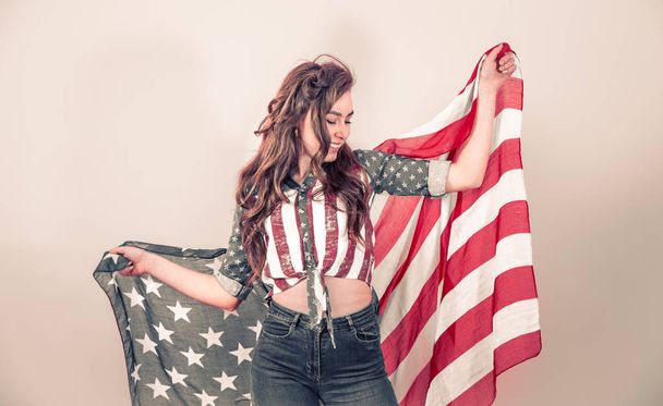 Patriotic girl with the flag of America on a colored background - Foto, Imagen
