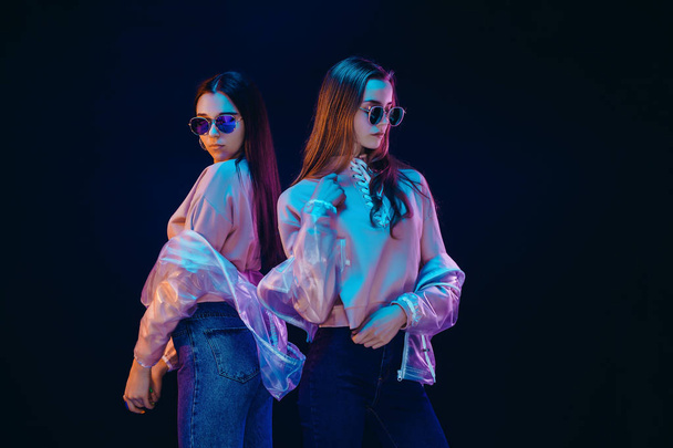 Stylish young women posing in neon light - Foto, afbeelding