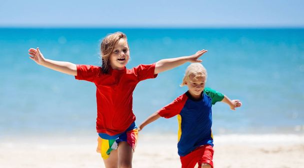 ビーチで遊ぶ子供たち。子供たちは海で遊ぶ. - 写真・画像