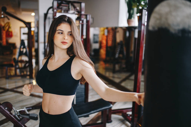 Ein schönes Mädchen ist in einem Fitnessstudio engagiert - Foto, Bild