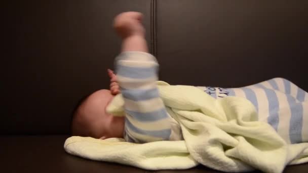 かわいい6ヶ月の男の子がソファで目を覚ますと彼の目をこすり - 映像、動画
