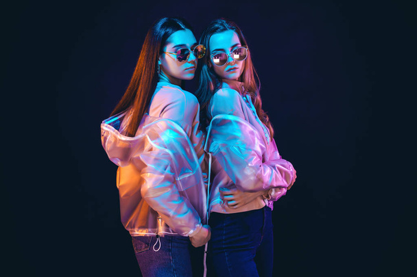 Stijlvolle jonge vrouwen poseren in neon licht - Foto, afbeelding