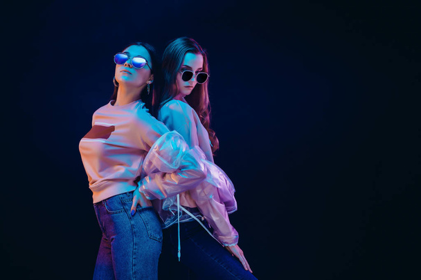 Stylish young women posing in neon light - Foto, Imagen