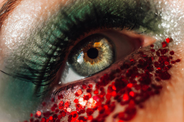 Макро зелене око з червоним мерехтливим боке. Креативна зйомка крупним планом
  - Фото, зображення