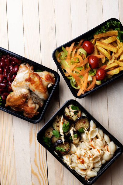 vista superior de pernas de frango, feijão, batatas fritas, salada, macarrão, berinjela em recipientes, almoço saudável  - Foto, Imagem