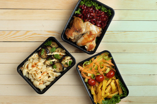 top view  of chicken legs, beans, french fries, salad, noodles, eggplant  in containers, healthy lunch  - Фото, изображение