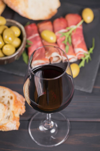 Kieliszek czerwonego wina z plastrów szynki lub hiszpański Jamon SERR - Zdjęcie, obraz