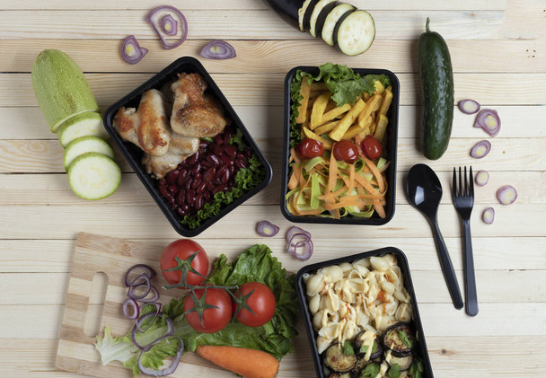 vista superior de comida saludable para llevar. vehículos, patas de pollo, frijoles, papas fritas, ensalada, fideos  - Foto, Imagen