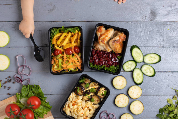 ręce dzieci w pobliżu kontenerów ekologicznych z gotowym posiłkiem do jedzenia, widok z góry, biznes pudełka na lunch - Zdjęcie, obraz