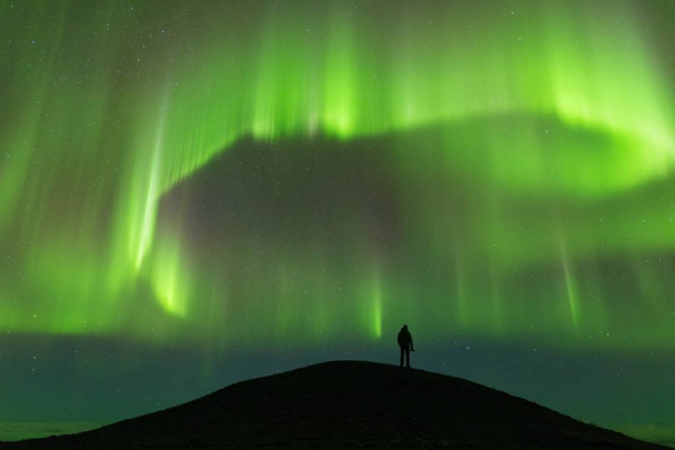 vista panorámica de las luces verdes del norte por encima de la silueta del hombre
 - Foto, Imagen